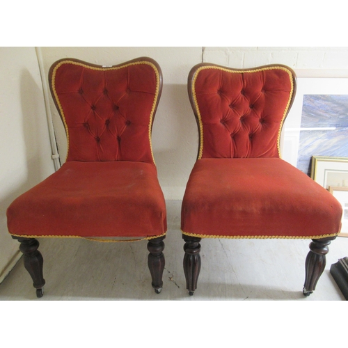 94 - A pair of late 19thC rosewood and mahogany showwood framed nursing chairs, the later part button red... 