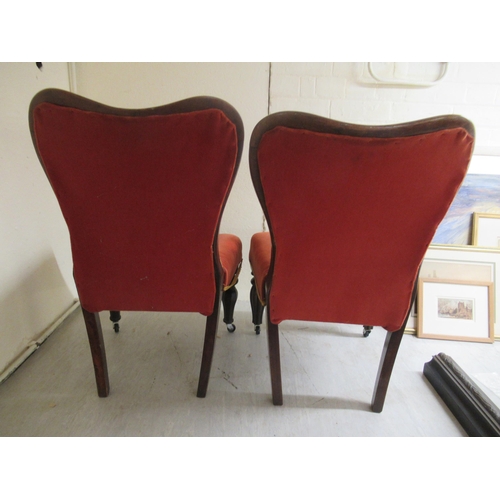 94 - A pair of late 19thC rosewood and mahogany showwood framed nursing chairs, the later part button red... 