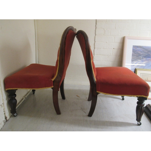 94 - A pair of late 19thC rosewood and mahogany showwood framed nursing chairs, the later part button red... 