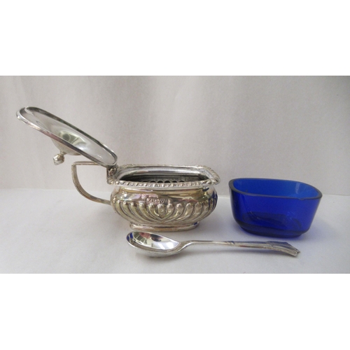 57 - A three piece silver condiments set of oval demi-reeded form  comprising two pepper pots; and a... 