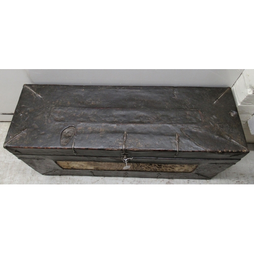 105 - A 19thC pine and hide covered chest with straight sides, a hinged lid and rivetted ornamental iron r... 