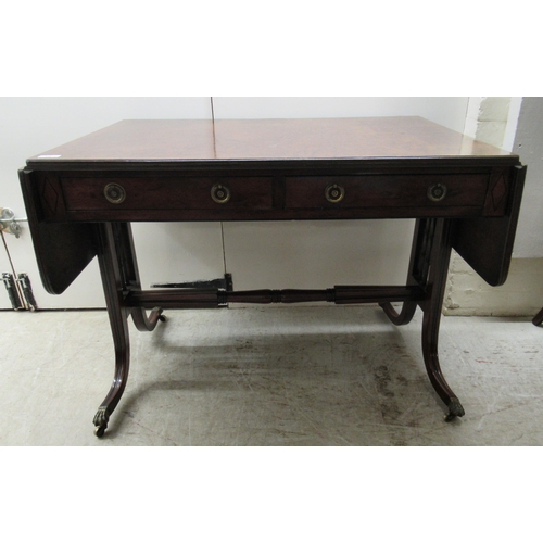 115 - A 19thC mahogany sofa table with ebony string inlaid decoration, the top having a reeded edge, over ... 