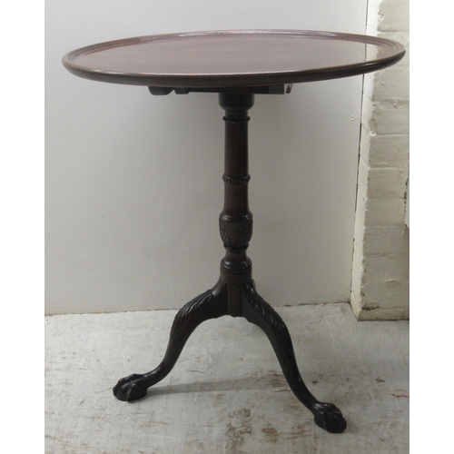 119 - A 19thC mahogany pedestal table, the turned top over a ring turned column with a foliate carved cabr... 