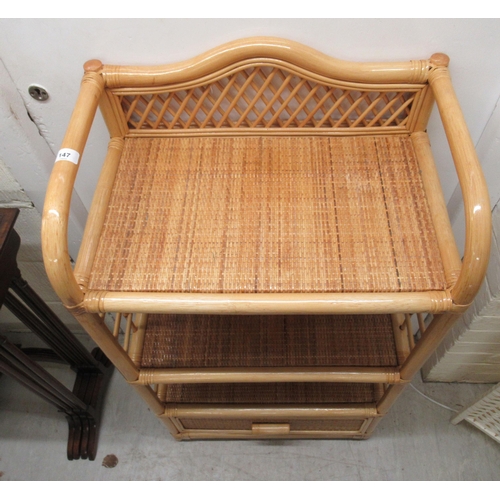 147 - A caned wicker three tier display unit with a base drawer  38