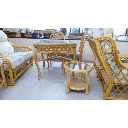 148 - Conservatory furniture: to include a caned framed three piece suite with floral patterned fabric cov... 