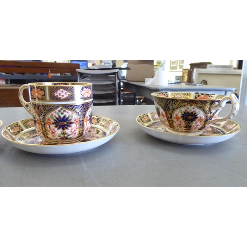 168 - Five Royal Crown Derby china cups and saucers, decorated in the Imari palette with gilding