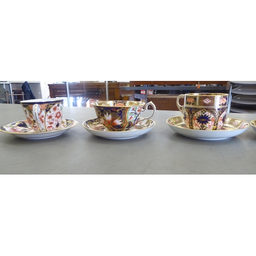 168 - Five Royal Crown Derby china cups and saucers, decorated in the Imari palette with gilding