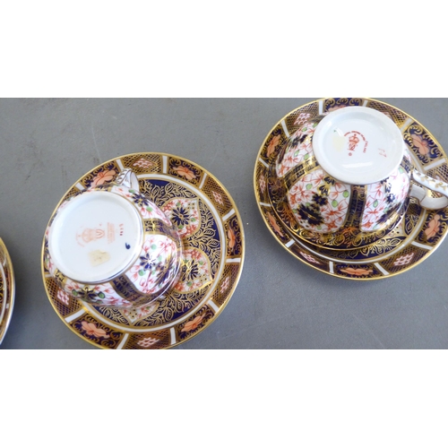 168 - Five Royal Crown Derby china cups and saucers, decorated in the Imari palette with gilding