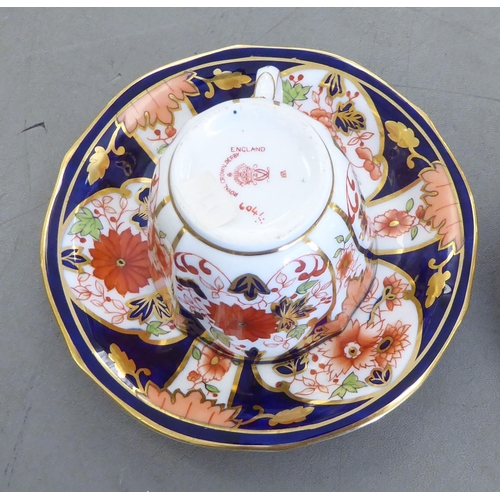 168 - Five Royal Crown Derby china cups and saucers, decorated in the Imari palette with gilding