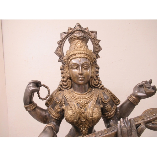 192 - A 20thC Asian patinated bi-coloured bronze Buddhist goddess with four arms, seated cross-legged, pla... 