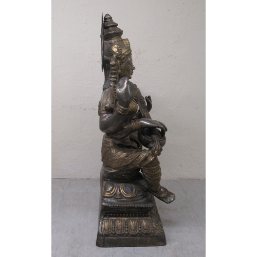 192 - A 20thC Asian patinated bi-coloured bronze Buddhist goddess with four arms, seated cross-legged, pla... 