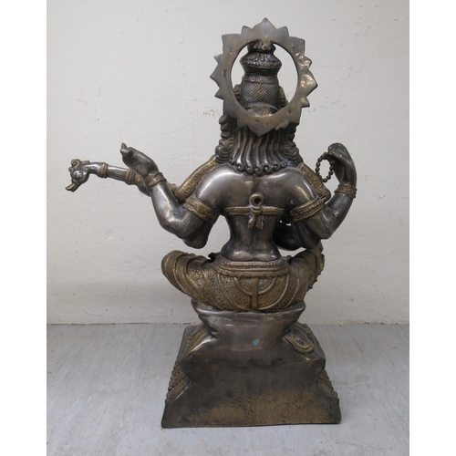 192 - A 20thC Asian patinated bi-coloured bronze Buddhist goddess with four arms, seated cross-legged, pla... 