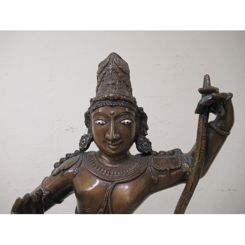 194 - A 20thC patinated bronze figure, Krishna, wearing ceremonial costumes, dancing with, and on, the hea... 