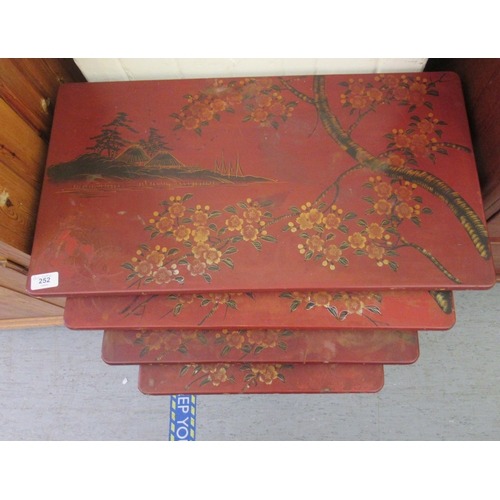 252 - A quartetto of post 1950s Japanese red lacquered and gilt highlighted occasional tables, each decora... 