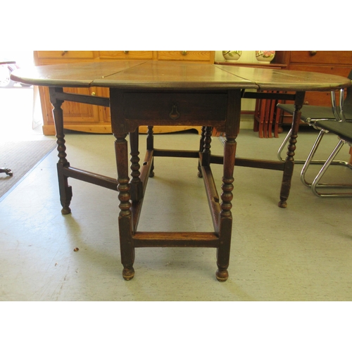 259 - A George III stained oak drop-leaf dining table, raised on bobbin turned and block supports  30