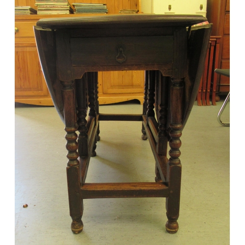 259 - A George III stained oak drop-leaf dining table, raised on bobbin turned and block supports  30