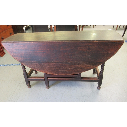 259 - A George III stained oak drop-leaf dining table, raised on bobbin turned and block supports  30