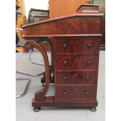 260 - A mid Victorian crossbanded mahogany and walnut Davenport with a hinged lidded compartment, over a t... 