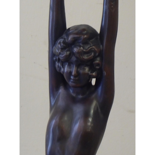 266 - An Art Deco inspired hollow bronze table lamp, fashioned as a nude, holding aloft a coloured lead gl... 