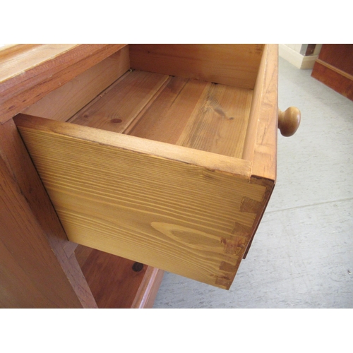 289 - A pair of modern pine bedside cabinets, each with a single drawer, over an open shelf, on a bracket ... 