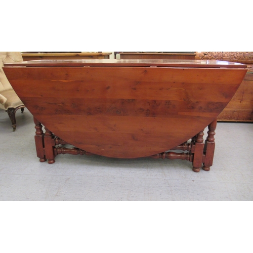 296 - A modern yewwood drop leaf/wake table, raised on turned baluster and block supports  29