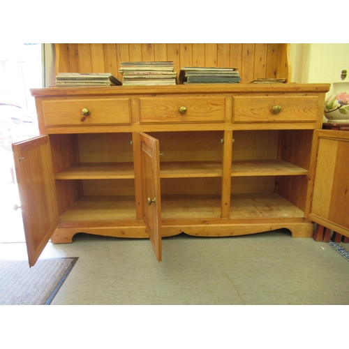 313 - A modern waxed pine dresser, the superstructure with two open plate rack shelves, over three frieze ... 