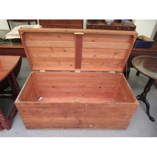 315 - An early 20thC rustically constructed pine chest with straight sides and a hinged lid, on a plinth  ... 