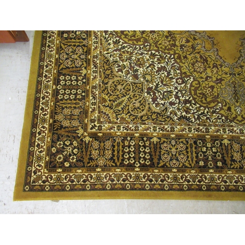 327 - An Indian inspired carpet, profusely decorated with flora and foliage, on a yellow/green ground ... 