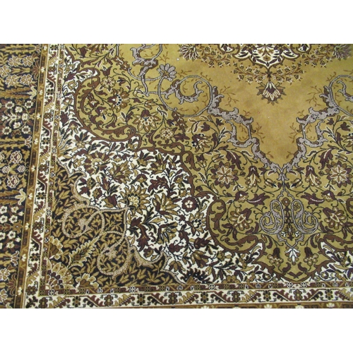 327 - An Indian inspired carpet, profusely decorated with flora and foliage, on a yellow/green ground ... 