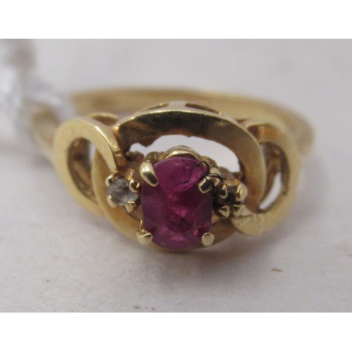 333 - An 18ct gold ring, set with a central ruby, flanked by two small diamonds