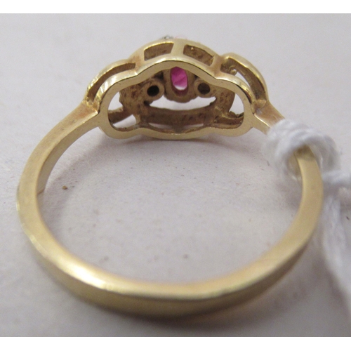 333 - An 18ct gold ring, set with a central ruby, flanked by two small diamonds