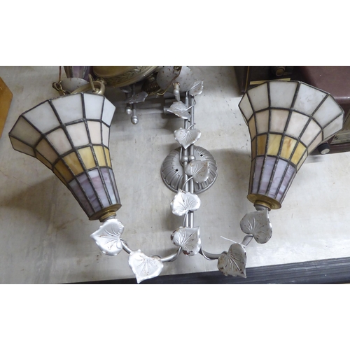 62 - Early 20thC lighting, in stylised silvered fittings: to include two pairs of wall lamps with coloure... 