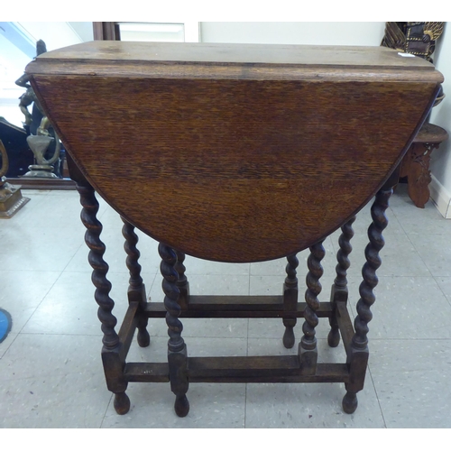 69 - A 1920s oak drop leaf tea table, raised on barleytwist legs  27