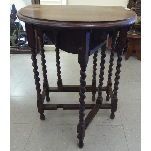 69 - A 1920s oak drop leaf tea table, raised on barleytwist legs  27