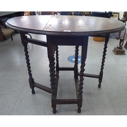 69 - A 1920s oak drop leaf tea table, raised on barleytwist legs  27