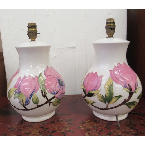 82 - A pair of Moorcroft pottery table lamps, decorated in relief in pastel tones with flora  12