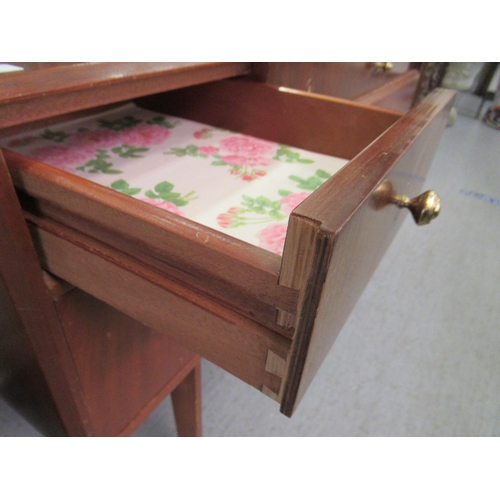 91 - A mid 20thC teak dressing table, surmounted by a mirror, over three frieze drawers, over two long dr... 