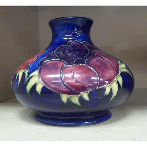 93 - A Moorcroft pottery vase of squat, bulbous form, decorated in relief with flora, on a blue ground&nb... 