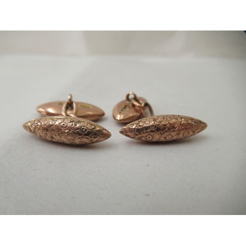 281 - A pair of 9ct gold cufflinks, on chains with engraved ornament