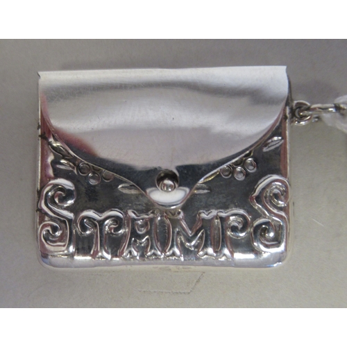 50 - A silver coloured metal envelope design pendant stamp case with a hinged cover