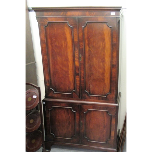 100 - A modern flame mahogany finished cabinet, the upper section with a pair of panelled doors and an int... 