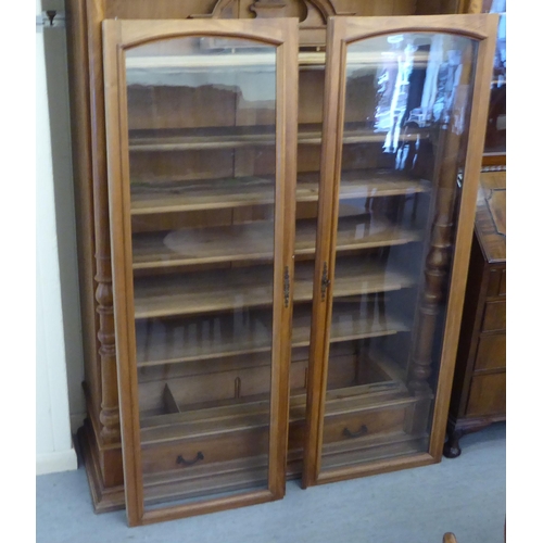 29 - An early 20thC French/Swiss walnut cabinet bookcase, having a straight cornice, over a pair of full ... 