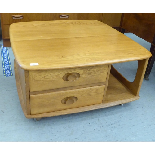 68 - An Ercol blonde elm coffee table, incorporating a pair of offset box drawers with recessed handles, ... 