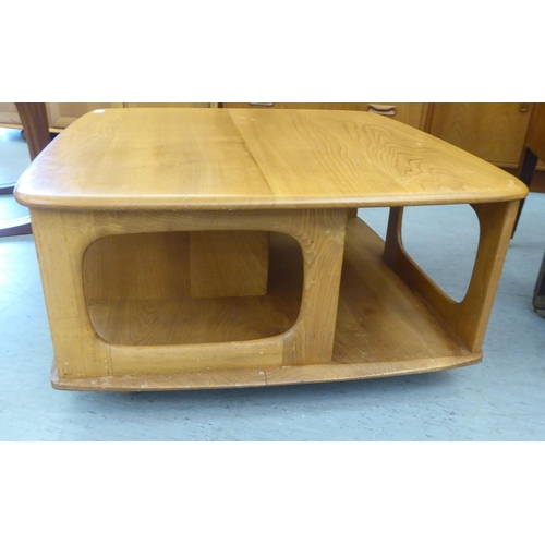 68 - An Ercol blonde elm coffee table, incorporating a pair of offset box drawers with recessed handles, ... 