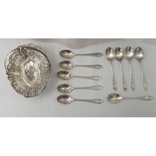 73 - A set of ten silver coffee spoons with engraved stems; and a silver sweet basket of oval form, with ... 