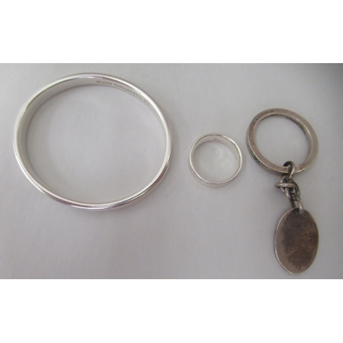 90 - Tiffany & Co silver, viz. a bangle, a band ring and a keyring, on a chain label