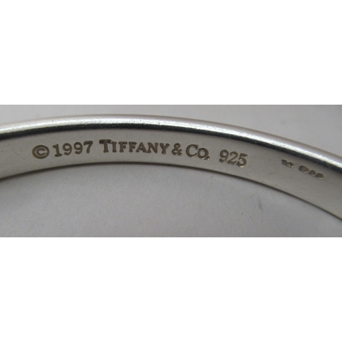 90 - Tiffany & Co silver, viz. a bangle, a band ring and a keyring, on a chain label