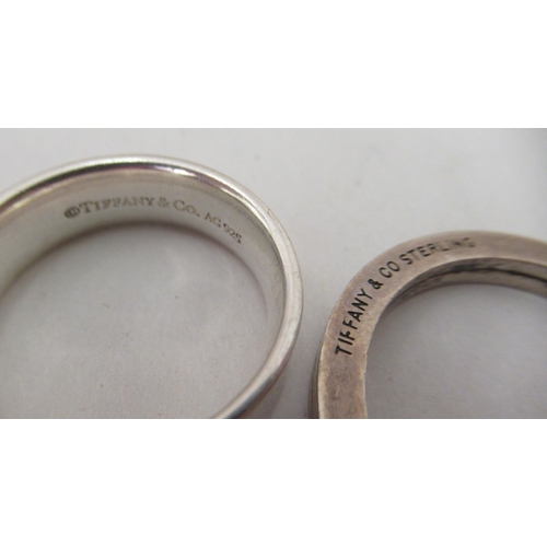 90 - Tiffany & Co silver, viz. a bangle, a band ring and a keyring, on a chain label