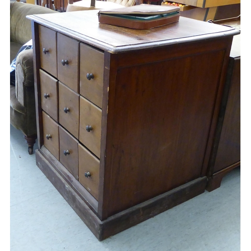 96 - A late 19thC stained pine cabinet, comprising an arrangement of nine equal compartmented box drawers... 