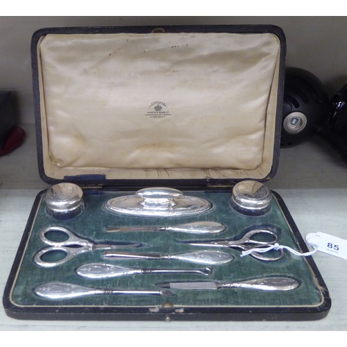 85 - A silver mounted ten piece manicure set with decoratively engraved ornament  Chester 1923  cased